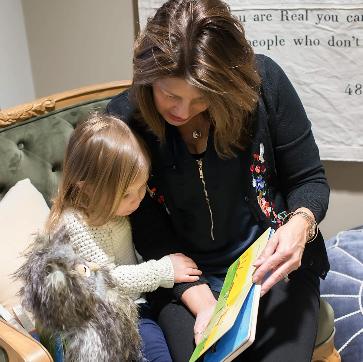 Kinderberry Hill teacher reading a book with a Kinderberry Hill child.